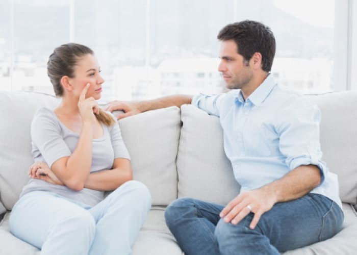 couple having a serious discussion on the couch