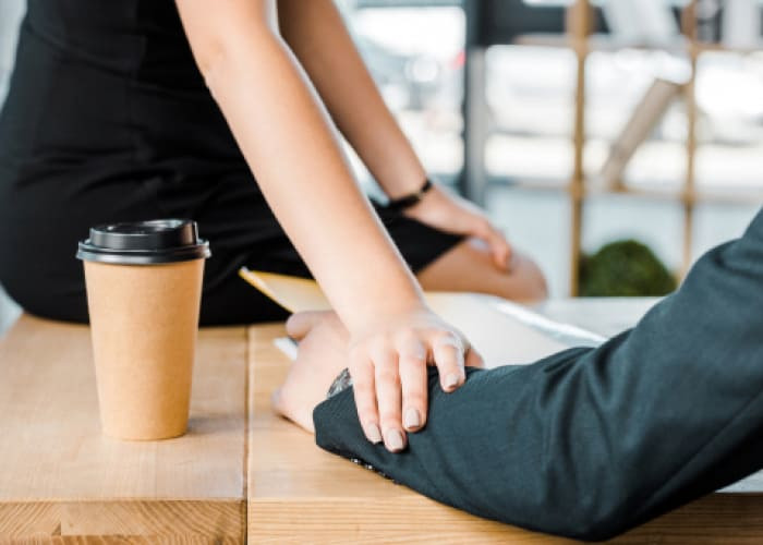 cropped shot of businesswoman flirting with colleague at workplace in office