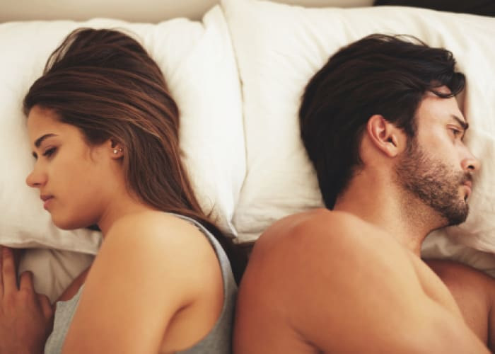 unhappy couple lying on bed