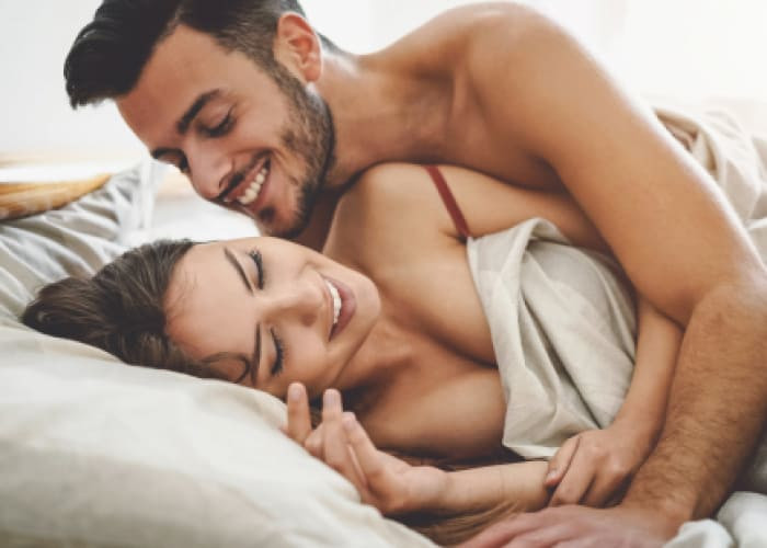 happy couple having fun on bed under blanket young romantic lovers intimate moments