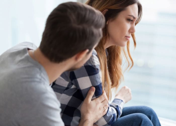 caring man comforting upset wife after fight