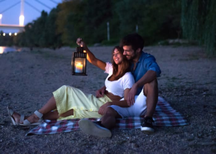 young couple having fun on the beach at night