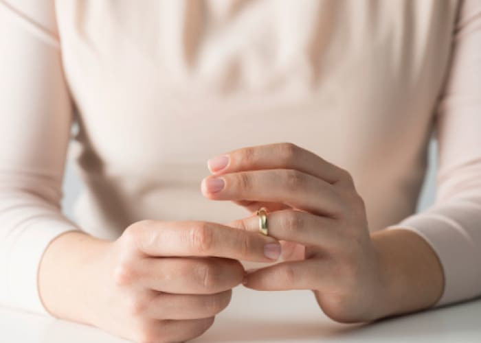 woman takes off her wedding ring