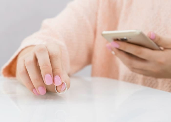 woman is taking off the wedding ring got a message from a smartphone