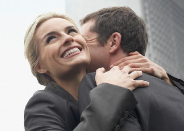 couple embracing outdoors near building smiling