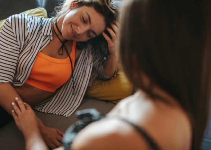 girl gently touches her female friend