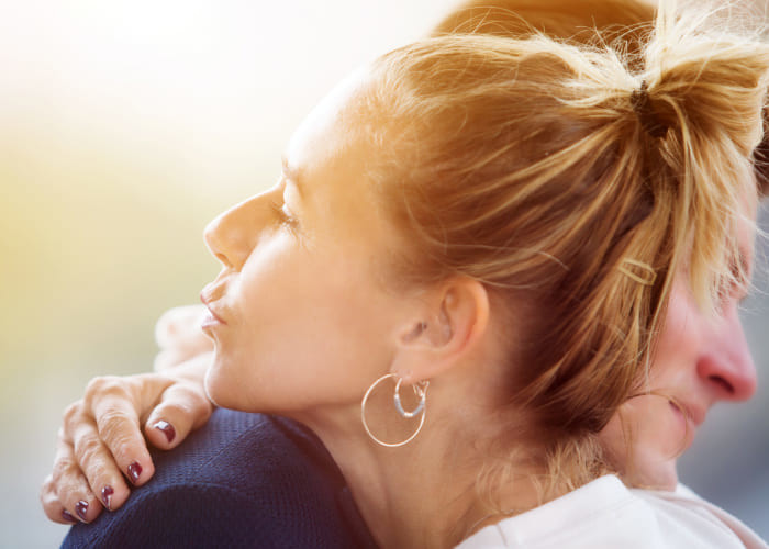 couple hugging while married woman blowing a kiss to another man