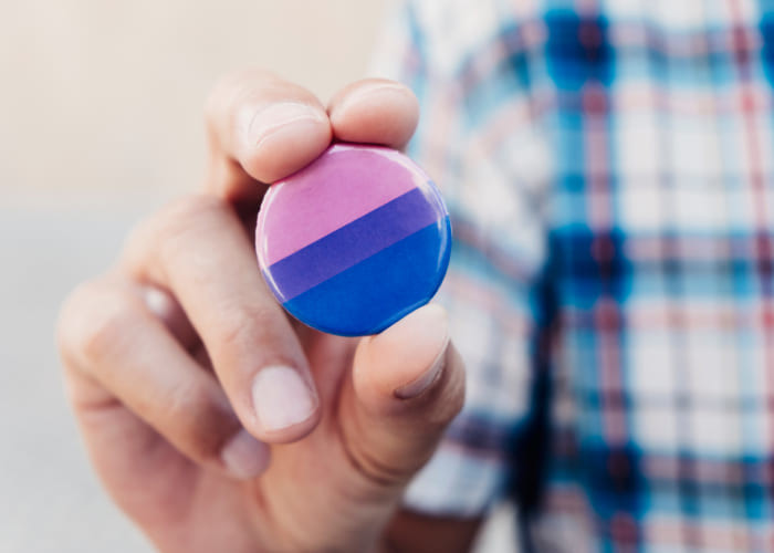 man with a bisexual pride flag badge