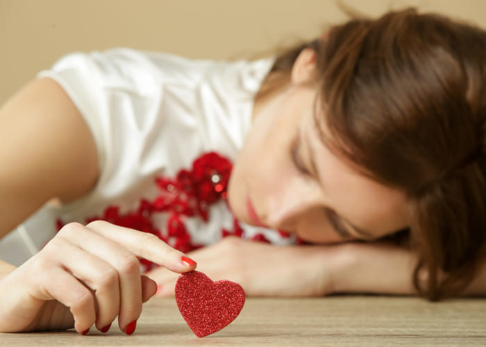 sad lonely woman holding red heart being alone