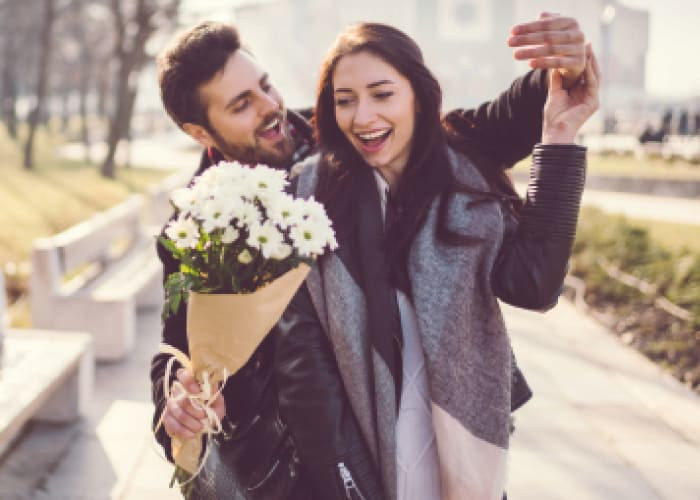 man presenting flowers to a lady