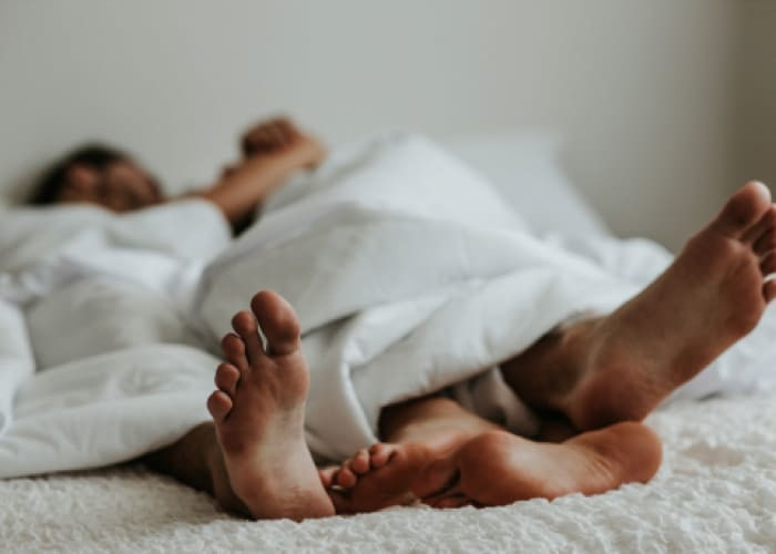 feet of a couple in a bed