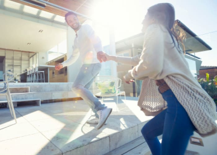 happy couple running in their home