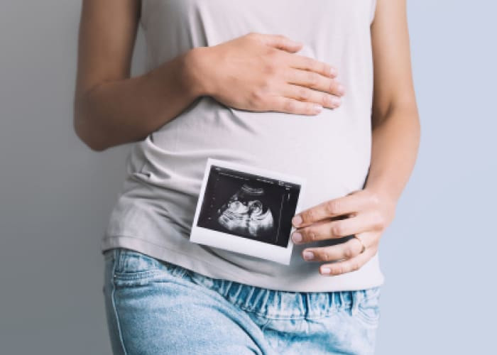 pregnant woman holding ultrasound baby image