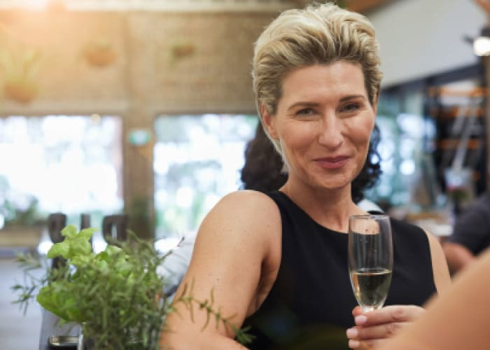 mature woman toasting with a glass of champagne	