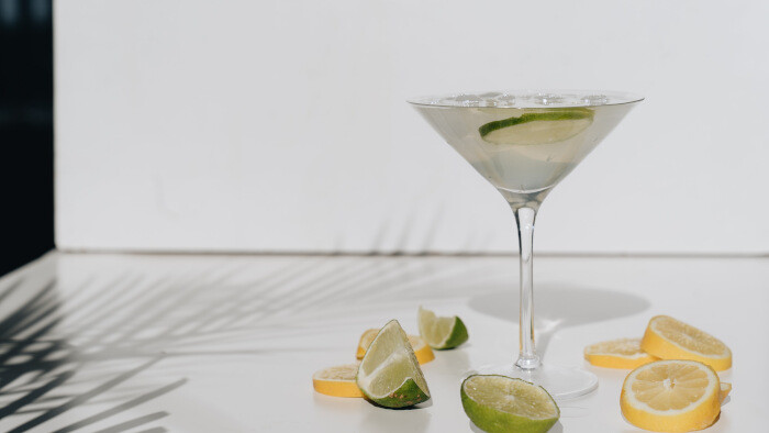 photo of citrus fruits beside cocktail glass 